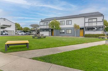 a park with a bench in front of an apartment building at The Gates at The Marina Apartments, California